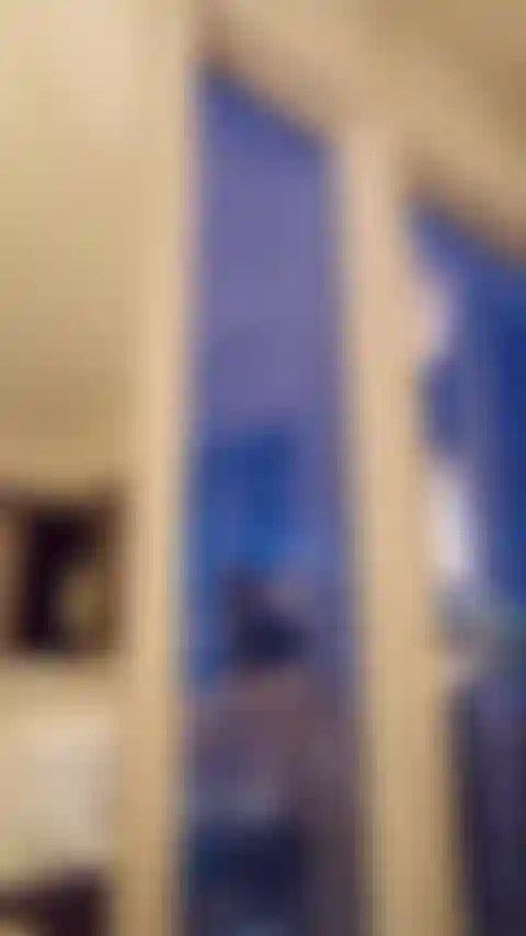 Elegant toy shows her body off to the city in the window of a high rise hotel.