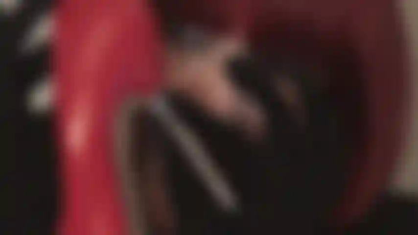 Licking shiny red stilettos.