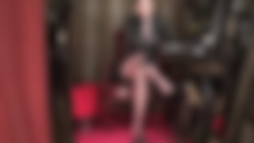 Mistress, here with sexy short hair, seduces with long legs in sheer pantyhose and a big white rubber cock in between them.