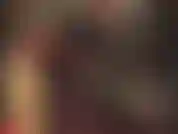 Skintight black latex catsuit and red gloves.