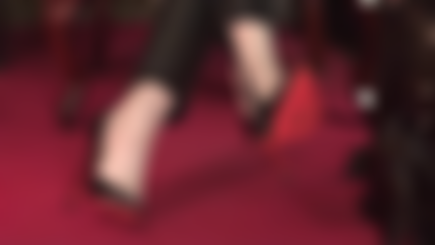 Mistress Vivian demands worship of her wonderful red sole black patent stiletto heels, pointing with her riding crop where you must lick.