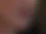 Closeup of face, lipstick and tongue tease as mistress teases with shiny red latex gloves.