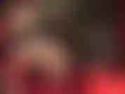 Side view of sexy legs in seamed stockings and garters dangling heels.