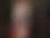 Mistress in white leather coat, red vinyl dress and pantyhose, wearing one of her big white strapons to have you drool over.