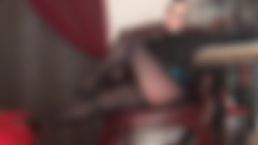 Mistress seduces with her legs in black high gloss pantyhose and a sexy cleavage in lace bra.