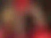 Mistress teases with her shapely thighs and long slender legs in glossy pantyhose and shiny red satin shorts.