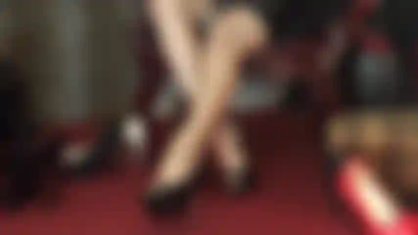 Pure seduction - crossed long legs that close and open in high gloss pantyhose, granting tempting views in between.