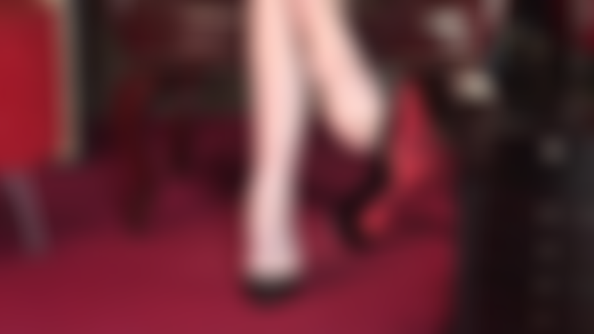 Pretty bare feet dangling red sole pumps.