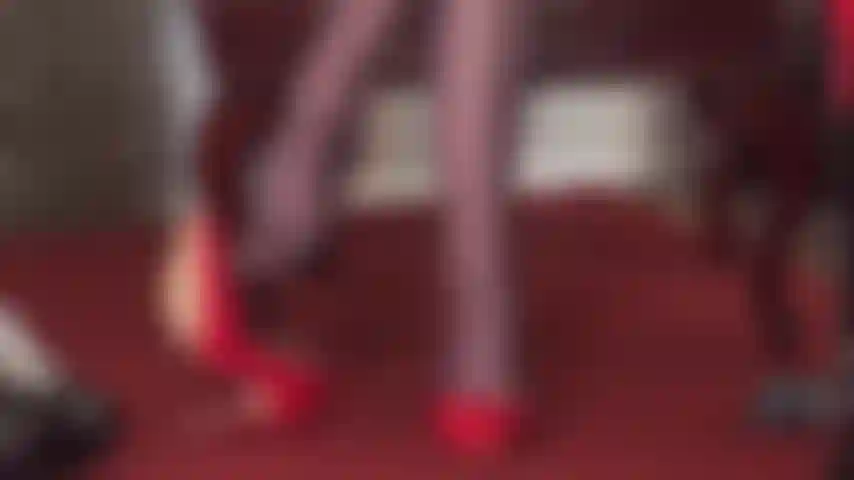 Mistress vivian shows off her dangling skills with a pair of shiny red pumps and dark brown glossy pantyhose, riding crop in hand.