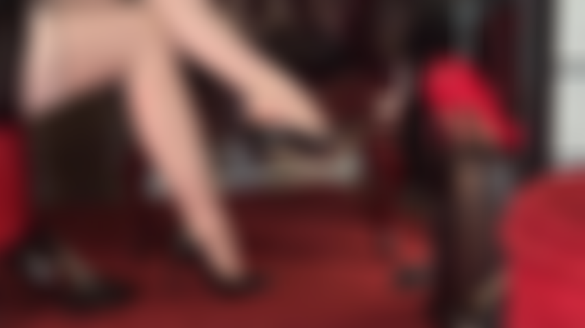 Nude garter patterned and seamed pantyhose crossed legs and seductive feet that dangle different pairs of classic pumps.