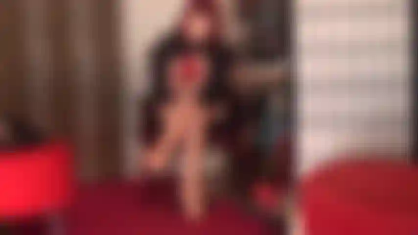 Tempting in red - mistress vivian slips on a pair of red lace top stockings over glossy nude pantyhose, red stiletto pumps and red leather gloves.