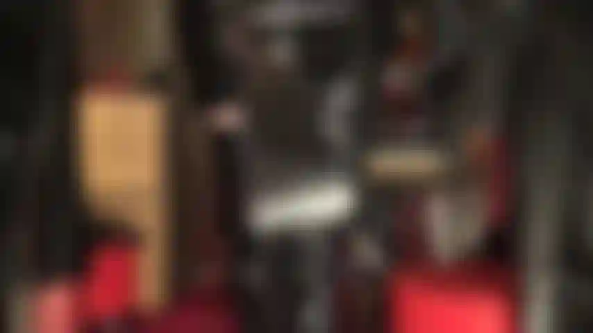 Shiny pvc fetish mistress with riding crop and overknees boots.