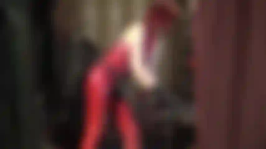 Massive black strapon and red rubber catsuit.