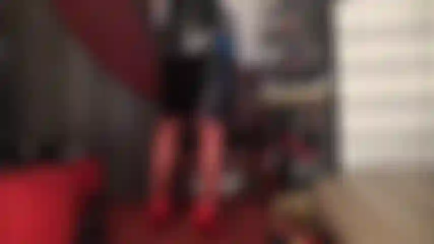 Red hosiery, heels and shiny black vinyl skirt.