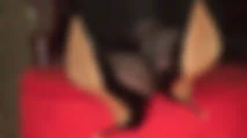 Dangling and shoe play with crossed ankles, feet up on ottoman.