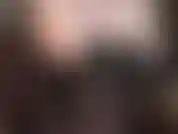 Sensual erotic tease with bare shoulders, armpits and cleavage in black leather corset, legs and black semi-opaque pantyhose.