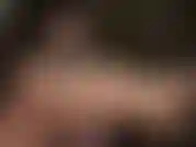 Mistress uses her lubricated shiny bare feet to stroke a black dildo.