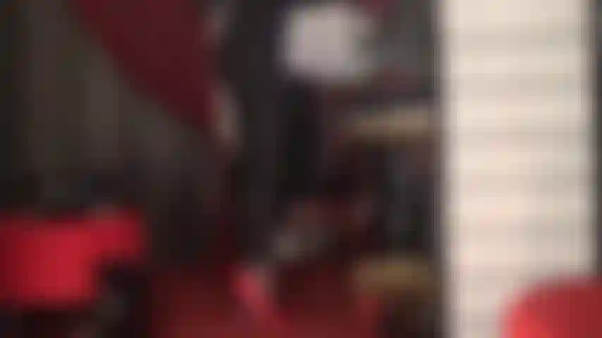 Red stiletto fetish heels and red lace thong on tight black catsuit.