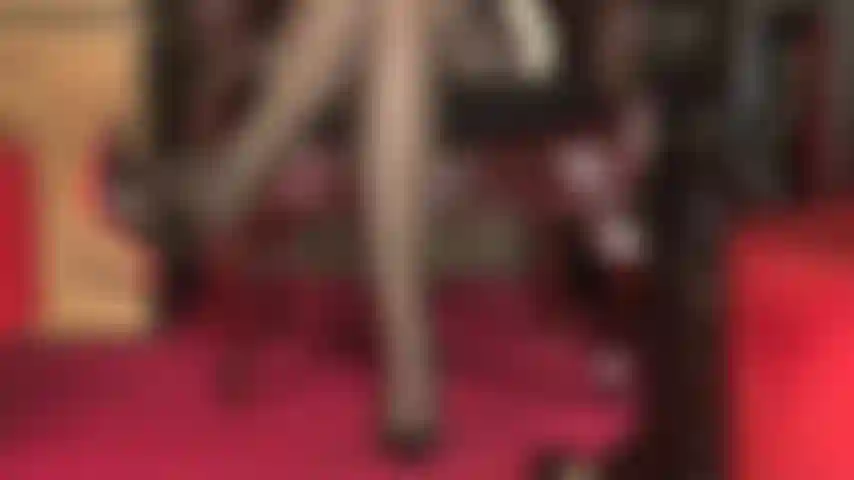 A sexy view onto stocking clad legs, multi-strap garter belt peeking, sexy crossed thighs and toes that dangle a red sole pump.