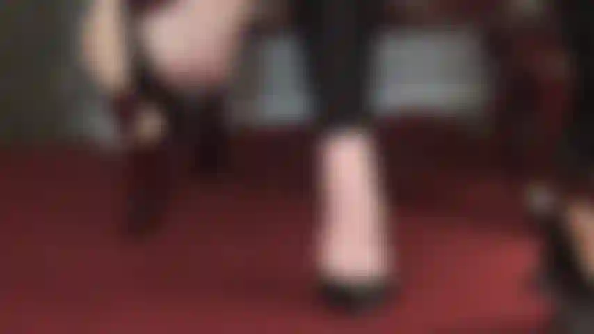 Soothing bare foot dangling - cute toes peeking out of leather pumps swinging the shoe skillfully.