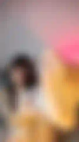 White lingerie babe in fishnets, caressing her feet & smiling playfully at the camera.